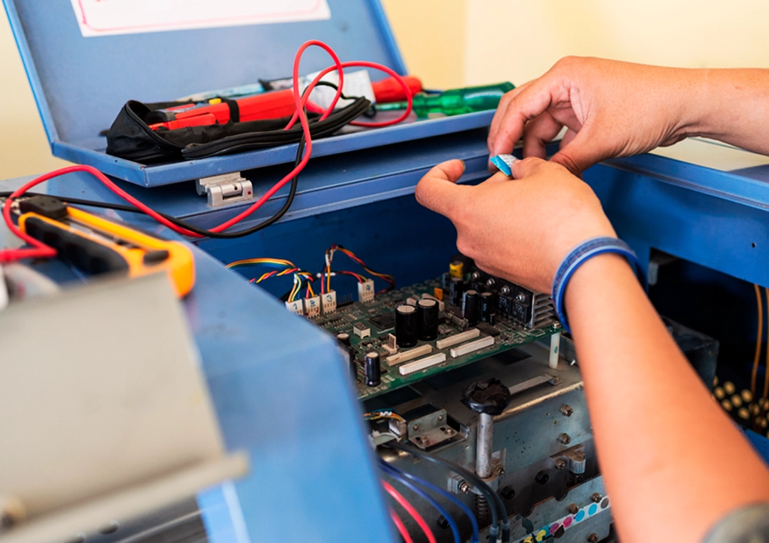 Colaborador Sorojet realizando manutenção, a impressora é azul e está aberta.